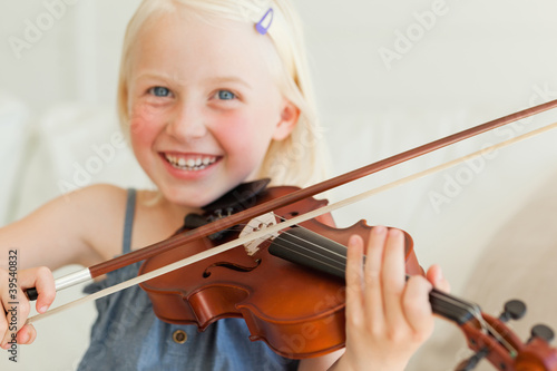 Photo: A cute girl enjoys playing the violin A cute girl enjoys playing the violin