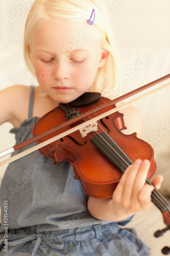 Photo: Sweet young girl softly plays the violin Sweet young girl softly plays the violin