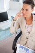 Thoughtful businesswoman in a beige suit with diagrams 