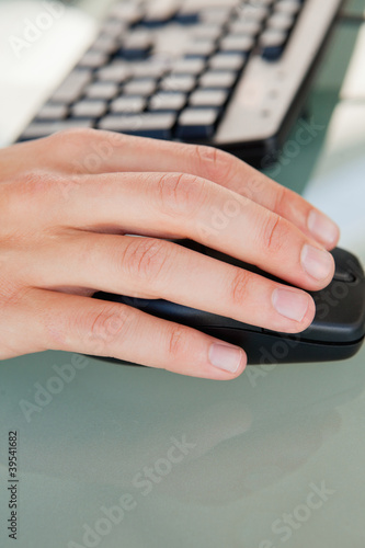 Photo: Close-up of man's hand moving a mouse Close-up of man's hand moving a mouse
