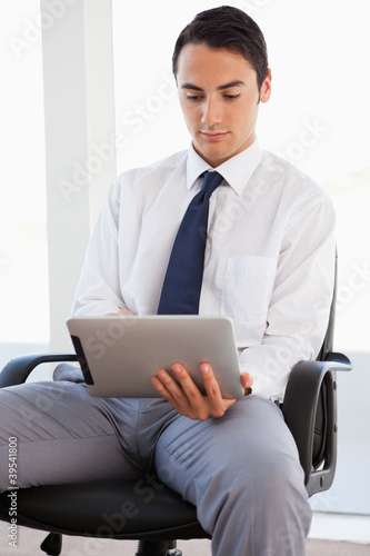 Photo: Businessman using a touchpad while sitting Businessman using a touchpad while sitting