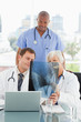 Mature doctor explains an x-ray to colleagues