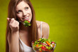 Photo: Healthy lifestyle - woman holding vegetable salad on green backg Healthy lifestyle - woman holding vegetable salad on green backg