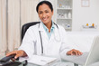 Smiling doctor hanging up the phone while sitting at the desk