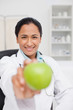 Smiling practitioner holding a green apple