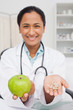 Delicious green apple and vitamins being held by a doctor