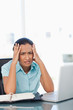 Foto: Upset secretary placing her hands on her temples while looking at the camera Upset secretary placing her hands on her temples while looking at the camera