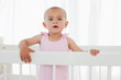 Beautiful baby standing up in her bed