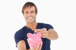 Piggy bank held by a man and receiving notes