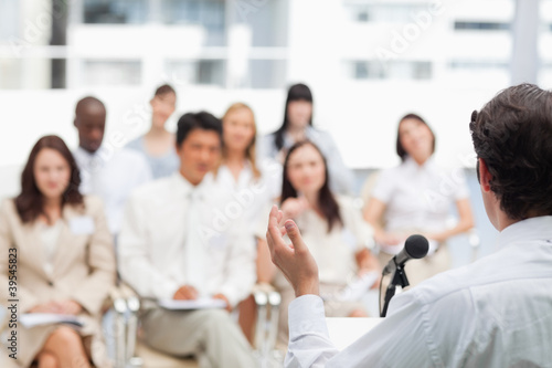 Photo: Brown haired man gesturing while giving a speech Brown haired man gesturing while giving a speech