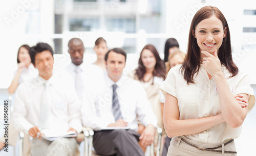 Photo: Brown haired businesswoman holding her hand against her chin Brown haired businesswoman holding her hand against her chin