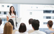 Businesswoman giving a speech while she is being watched