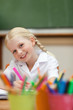 Happy smiling girl painting in class