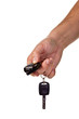 Hand holding car keys and a remote contro