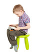 boy with a Tablet PC sitting on a green children's chair