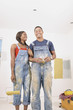Portrait of couple in overalls painting