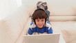 Boy using a laptop is wearing headphone 
