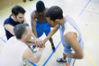 High angle view of coach and basketball players in huddle