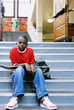 Portrait of boy with skateboard on school stairs
