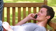 Video: Man laughing and talking on his phone before hanging up and looking at the camera Man laughing and talking on his phone before hanging up and looking at the camera