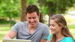 Video: Woman laughing as she watches a laptop with her friend before playfully pushing him Woman laughing as she watches a laptop with her friend before playfully pushing him