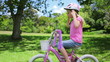 Girl puts on a cycling helmet and holds the handle bars