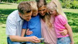 Video: Family looking at the photo gallery of a camera before looking towards the camera Family looking at the photo gallery of a camera before looking towards the camera