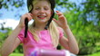 Girl puts on a pink cycling helmet and fastens the clasps