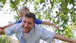 Video: Father giving his son a piggy-back while they have their arms spread before holding him Father giving his son a piggy-back while they have their arms spread before holding him