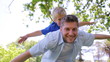 Video: A father sways from side to side while giving his son a piggy back with his arms spread A father sways from side to side while giving his son a piggy back with his arms spread
