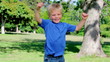 Vidéo : Boy jumps around and spinning with his arms spread before stopping and looking at the camera Boy jumps around and spinning with his arms spread before stopping and looking at the camera