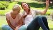 Video: Woman sitting as her friend sits down with her as they then talk and look to the side Woman sitting as her friend sits down with her as they then talk and look to the side