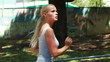A moving side view of a woman jogging down a road looking around her