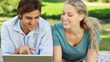 Video: Woman lies down beside her boyfriend as they watch a laptop and then look into the camera Woman lies down beside her boyfriend as they watch a laptop and then look into the camera