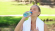 A woman takes a drink of water as the camera changes to a side view