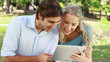 Video: A couple use a tablet together as they then look at the camera A couple use a tablet together as they then look at the camera