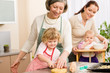 Little girl cutting dough for cookies