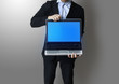 Foto: hand gesture next to a laptop and business graphs hand gesture next to a laptop and business graphs