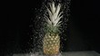 Water raining on pineapple in super slow motion