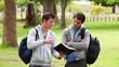 Video: Man using a book to explain something to his friend who has his arms crossed Man using a book to explain something to his friend who has his arms crossed