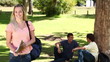 Video: Woman waving towards her friends who are sitting behind her before she looks at the camera Woman waving towards her friends who are sitting behind her before she looks at the camera