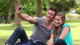 Video: Two friends sitting together before using a camera to take a picture of themselves Two friends sitting together before using a camera to take a picture of themselves