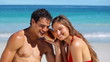 Smiling couple listening to a seashell