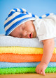 Sleeping baby on colorful towels stack Sleeping baby on colorful towels stack