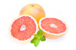 Ganze und halbierte Grapefruit mit einem Blatt Minze