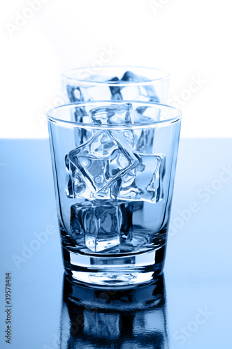 Foto: Glasses with crystal clear ice cubes on glossy background Glasses with crystal clear ice cubes on glossy background