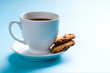 Foto: Coffee cup with cookies on blue background Coffee cup with cookies on blue background