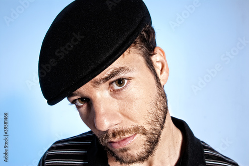 Photo: Young modern man portrait handsome hat blue background Young modern man portrait handsome hat blue background