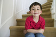 Portrait of young boy sitting on stairs