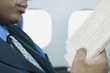 Businessman reading newspaper on airplane